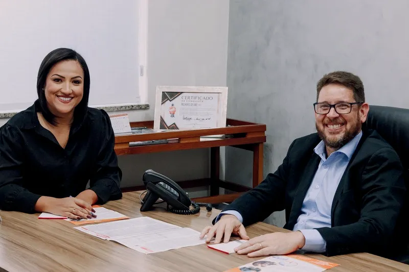Dayane Gomes Alves e Francis Henrique da Silva, sócios do escritório, sentados à mesa de reunião